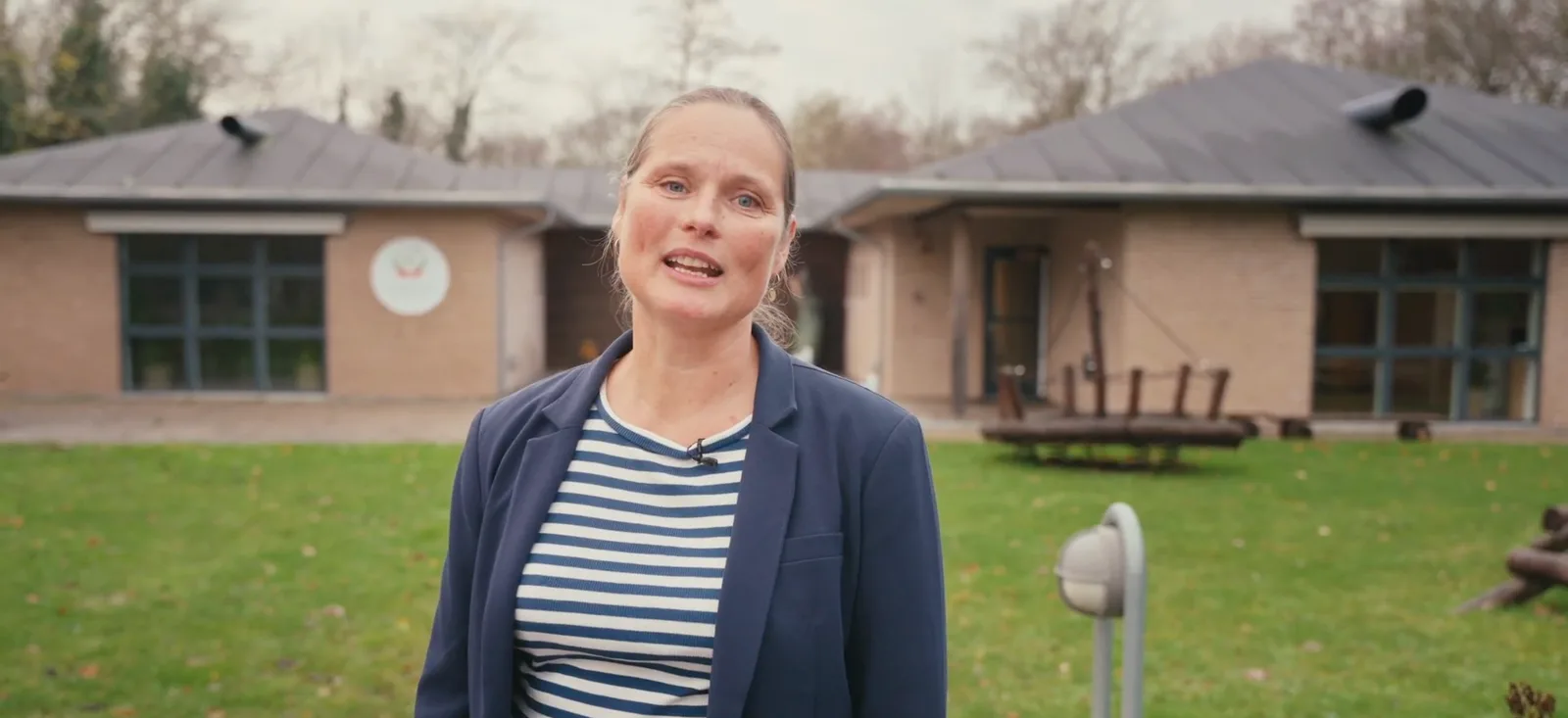 Dorthe byder velkommen foran Familiehuset